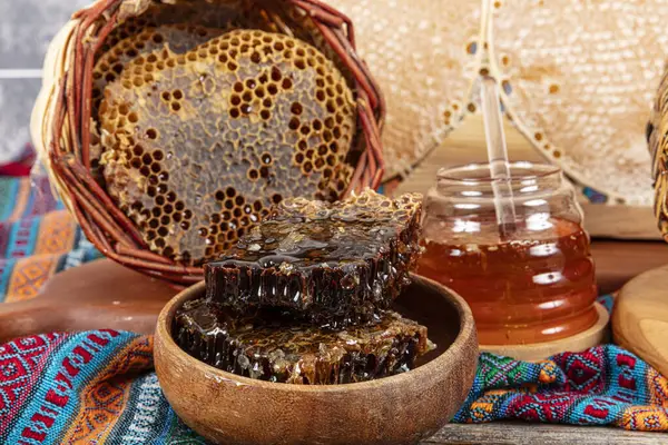 stock image Magical honeycomb close up, Honey harvesting, honey picking. Organic honeycomb (Turkish Karakovan Honey). Organic honeycomb in jar with honey dipper on vintage wooden background.