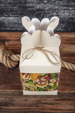 Kurutulmuş meyve çeşitleriyle dolu bir hediye kutusu. Fındık, kurutulmuş meyve ve şekerler kutuda, işe yarar bir hediye..