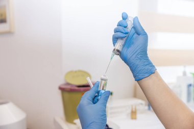 Doktor iğneyi yapmaya hazırlanıyor. Doktor, kadın hemşire ya da anestezi uzmanı. Sağlık ve aşı için tıbbi enjeksiyon konsepti uyguluyor. seçici odak.
