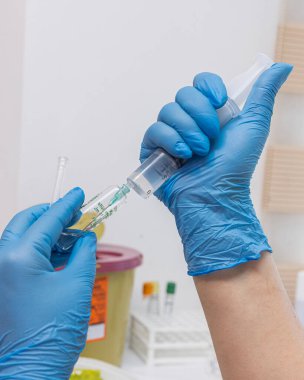 Doktor iğneyi yapmaya hazırlanıyor. Doktor, kadın hemşire ya da anestezi uzmanı. Sağlık ve aşı için tıbbi enjeksiyon konsepti uyguluyor. seçici odak.