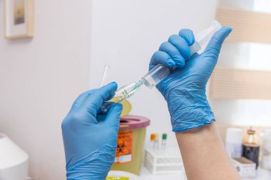 Doktor iğneyi yapmaya hazırlanıyor. Doktor, kadın hemşire ya da anestezi uzmanı. Sağlık ve aşı için tıbbi enjeksiyon konsepti uyguluyor. seçici odak.