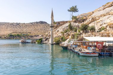 Sanliurfa 'nın Halfeti kasabasında terk edilmiş eski kasaba manzarası. Halfeti köyü ve batık minaresi ve turnuva botlarından oluşan Türk bayrakları. Türkiye 'nin Sanliurfa kentindeki batık kent Halfeti manzarası.