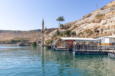 Sanliurfa 'nın Halfeti kasabasında terk edilmiş eski kasaba manzarası. Halfeti köyü ve batık minaresi ve turnuva botlarından oluşan Türk bayrakları. Türkiye 'nin Sanliurfa kentindeki batık kent Halfeti manzarası.