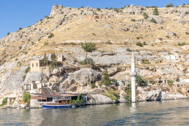 Sanliurfa 'nın Halfeti kasabasında terk edilmiş eski kasaba manzarası. Halfeti köyü ve batık minaresi ve turnuva botlarından oluşan Türk bayrakları. Türkiye 'nin Sanliurfa kentindeki batık kent Halfeti manzarası.