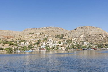 Sanliurfa 'nın Halfeti kasabasında terk edilmiş eski kasaba manzarası. Halfeti köyü ve batık minaresi ve turnuva botlarından oluşan Türk bayrakları. Türkiye 'nin Sanliurfa kentindeki batık kent Halfeti manzarası.