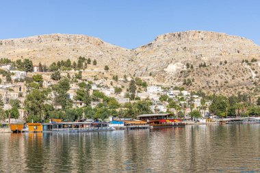 Sanliurfa 'nın Halfeti kasabasında terk edilmiş eski kasaba manzarası. Halfeti köyü ve batık minaresi ve turnuva botlarından oluşan Türk bayrakları. Türkiye 'nin Sanliurfa kentindeki batık kent Halfeti manzarası.