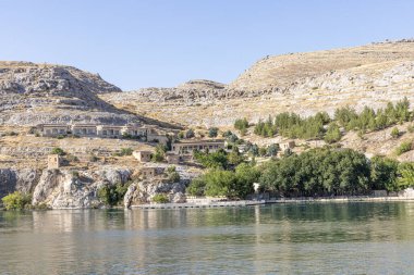 Sanliurfa 'nın Halfeti kasabasında terk edilmiş eski kasaba manzarası. Halfeti köyü ve batık minaresi ve turnuva botlarından oluşan Türk bayrakları. Türkiye 'nin Sanliurfa kentindeki batık kent Halfeti manzarası.