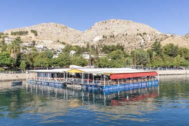 Sanliurfa 'nın Halfeti kasabasında terk edilmiş eski kasaba manzarası. Halfeti köyü ve batık minaresi ve turnuva botlarından oluşan Türk bayrakları. Türkiye 'nin Sanliurfa kentindeki batık kent Halfeti manzarası.