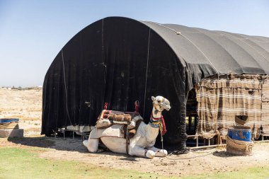 Sıcak bir günde deve, arka planda Harran köyünde Harran evleri, Şanlıurfa, Türkiye.