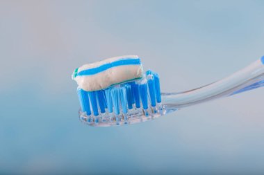 Diş fırçası ve diş macunu, diş fırçasına diş macunu sıkmak. Diş macununu bulanık arkaplana sürme, kapat.