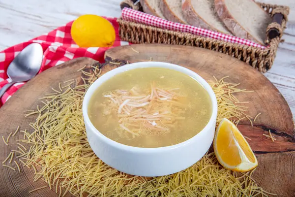 stock image Traditional Turkish Cuisine Homemade chicken soup prepared with vermicelli (noodles) and vegetables in a white bowl. Turkish name; Tel sehriye corbasi.