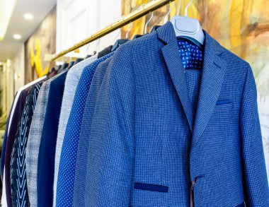 Erkek ceketleri mağazadaki askılarda asılı. Askıya asılmış erkek takımları. Erkek giyim koleksiyonu.