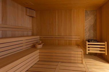 Finlandiya saunasının içi, sıcak buharlı klasik ahşap sauna. Otel SPA merkezindeki sauna odası. Ahşap iç banyolar, ahşap banklar ve güneş pansiyonları sauna aksesuarları, spa kompleksi..