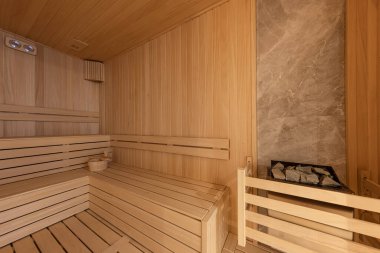 Finlandiya saunasının içi, sıcak buharlı klasik ahşap sauna. Otel SPA merkezindeki sauna odası. Ahşap iç banyolar, ahşap banklar ve güneş pansiyonları sauna aksesuarları, spa kompleksi..