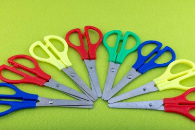 Renkli okul makası. Çocuk boyalı makas. Kağıt kesme makası. Renkli bir arkaplanda birçok makas türü.