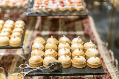 Pasta tezgahları pastalarla dolu bir pastane. Masada bir sürü tatlı, çeşitli hamur işi ürünleri ve çikolatalı çörekler, şeker bağımlılığı. Kahve ve tatlı atıştırmalıklar..