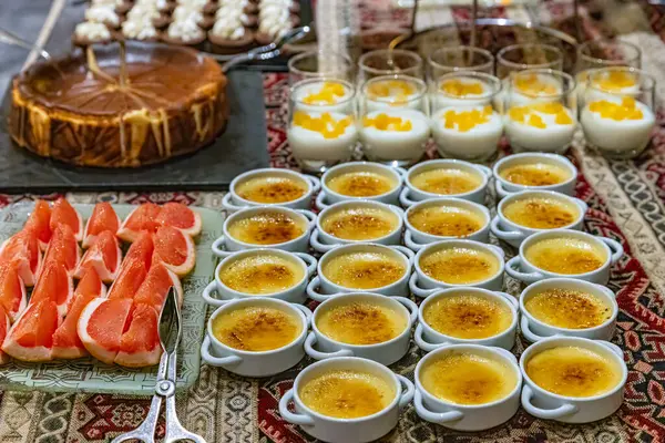 stock image A bakery counter filled with cakes on cake stands. Lots of sweets on a table, variation of pastry products and donuts with chocolate, sugar addiction. Coffee bake and sweet snacks.