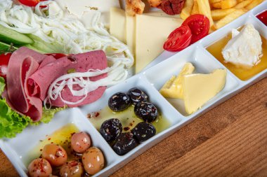 Restoranda kahvaltı hazırlayan bayan, yumurta, ekmek, zeytin ve salatadan oluşan bir Türk kahvaltı tabağı. Tanınmayan kadın lezzetli yemeğinin tadını çıkarırken çatal ve bıçak kullanıyor.