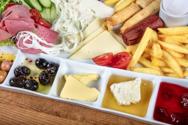 Restoranda kahvaltı hazırlayan bayan, yumurta, ekmek, zeytin ve salatadan oluşan bir Türk kahvaltı tabağı. Tanınmayan kadın lezzetli yemeğinin tadını çıkarırken çatal ve bıçak kullanıyor.