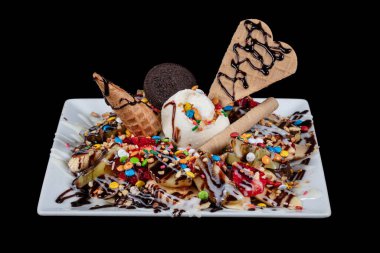 Ev yapımı Belçika waffle 'ı, çilekli ve kremalı harika olur. Porselen tabakta çikolatalı waffle, meyve ve dondurma. Siyah bir arkaplanda izole edilmiş.