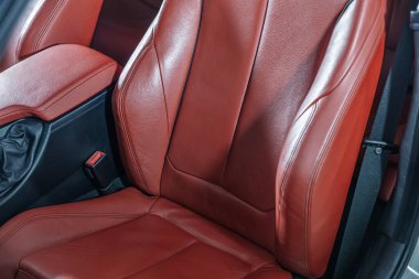 Araba içeride. Prestijli modern araba. Rahat kırmızı deri koltuklar. Deri kokpit, modern araba iç mimarisi..