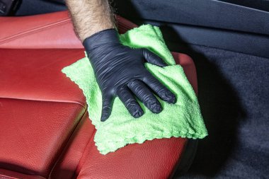Arabanın içini yeşil mikrofiber bezle elle temizliyorum. El mikrofiber bez, deri koltuk temizleme, araba temizleme ve vale konsepti, araba yıkama..