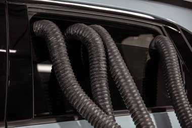 Profesyonel Araba Koltuğu Kurutma Sıcak Hava Yapımcısı Ahtapot. Servis oto yıkama ekspresi. İşçi su damlalarını temizlemek için turbo kurutucu kullanıyor. Detaylandırma, araba yıkama ve boya düzeltme konsepti.