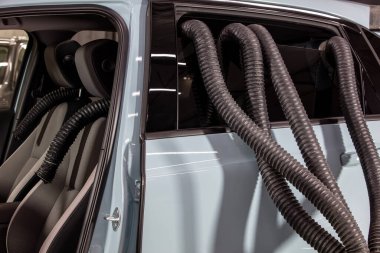 Profesyonel Araba Koltuğu Kurutma Sıcak Hava Yapımcısı Ahtapot. Servis oto yıkama ekspresi. İşçi su damlalarını temizlemek için turbo kurutucu kullanıyor. Detaylandırma, araba yıkama ve boya düzeltme konsepti.