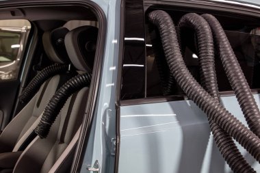 Profesyonel Araba Koltuğu Kurutma Sıcak Hava Yapımcısı Ahtapot. Servis oto yıkama ekspresi. İşçi su damlalarını temizlemek için turbo kurutucu kullanıyor. Detaylandırma, araba yıkama ve boya düzeltme konsepti.