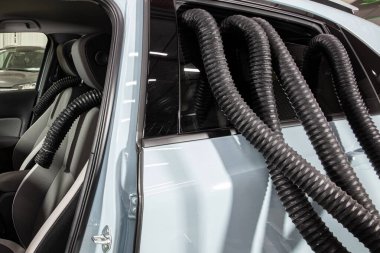 Profesyonel Araba Koltuğu Kurutma Sıcak Hava Yapımcısı Ahtapot. Servis oto yıkama ekspresi. İşçi su damlalarını temizlemek için turbo kurutucu kullanıyor. Detaylandırma, araba yıkama ve boya düzeltme konsepti.