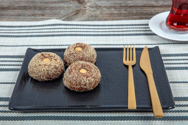 Traditional Turkish Dessert Sekerpare is also known as Chocolate Sekerpare with White Poppy Seeds, Sherbet and Pistachios. clipart