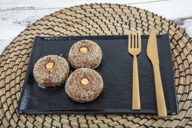 Traditional Turkish Dessert Sekerpare is also known as Chocolate Sekerpare with White Poppy Seeds, Sherbet and Pistachios. clipart