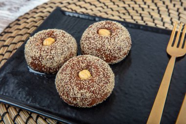 Traditional Turkish Dessert Sekerpare is also known as Chocolate Sekerpare with White Poppy Seeds, Sherbet and Pistachios. clipart