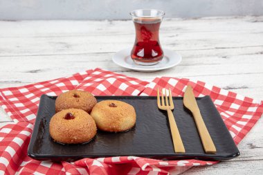 Sekerpare tatlı. Ramazan tatlısı. Şerbetli Sekerpare tatlı ve servis tabağında Türk çayı..