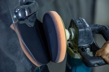 Araba Lehçe balmumu işçisi uygulanan koruyucu bant parlatma önce eller. Polisaj ve parlatma araba. Araba ayrıntılı. Adam elinde bir Parlatıcı tutar ve araba parlatır