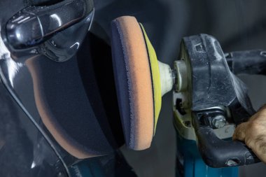 Araba Lehçe balmumu işçisi uygulanan koruyucu bant parlatma önce eller. Polisaj ve parlatma araba. Araba ayrıntılı. Adam elinde bir Parlatıcı tutar ve araba parlatır