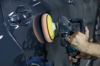 Araba Lehçe balmumu işçisi uygulanan koruyucu bant parlatma önce eller. Polisaj ve parlatma araba. Araba ayrıntılı. Adam elinde bir Parlatıcı tutar ve araba parlatır