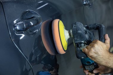 Araba Lehçe balmumu işçisi uygulanan koruyucu bant parlatma önce eller. Polisaj ve parlatma araba. Araba ayrıntılı. Adam elinde bir Parlatıcı tutar ve araba parlatır