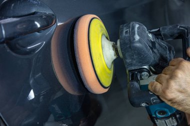 Araba Lehçe balmumu işçisi uygulanan koruyucu bant parlatma önce eller. Polisaj ve parlatma araba. Araba ayrıntılı. Adam elinde bir Parlatıcı tutar ve araba parlatır