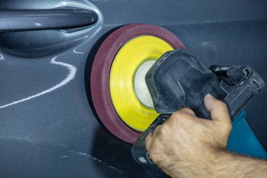 Araba Lehçe balmumu işçisi uygulanan koruyucu bant parlatma önce eller. Polisaj ve parlatma araba. Araba ayrıntılı. Adam elinde bir Parlatıcı tutar ve araba parlatır