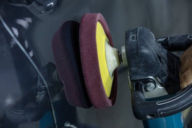 Araba Lehçe balmumu işçisi uygulanan koruyucu bant parlatma önce eller. Polisaj ve parlatma araba. Araba ayrıntılı. Adam elinde bir Parlatıcı tutar ve araba parlatır