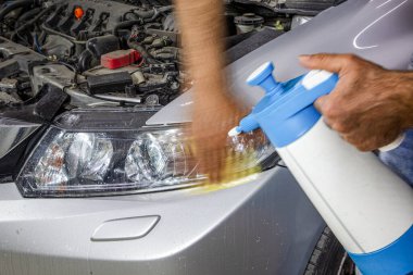 Araba servisinde güç tamponu makinesiyle araba farları temizleniyor. Benzin istasyonunda tampon makinesi olan büyük bir far temizliği. Araba temizleme konsepti. Otomatik temizlik ve cilalama.