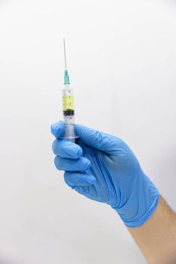 Şırıngaya şırınga ve ilaç enjekte edilmiş. Hemşire, klinikteki bir şırıngaya solüsyon çeker. Hemşire şırıngadan hava alıyor..