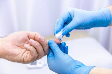 Hastanın kan örneğini parmak batırma kiti ile alan tıbbi çalışanın yakın çekimi. Tıbbi konsept. Diyabet konsepti. Kanında şeker var. Sağlık konsepti. Glikoz ölçer elinde.