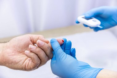 Hastanın kan örneğini parmak batırma kiti ile alan tıbbi çalışanın yakın çekimi. Tıbbi konsept. Diyabet konsepti. Kanında şeker var. Sağlık konsepti. Glikoz ölçer elinde.