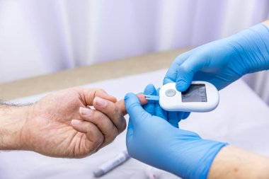 Hastanın kan örneğini parmak batırma kiti ile alan tıbbi çalışanın yakın çekimi. Tıbbi konsept. Diyabet konsepti. Kanında şeker var. Sağlık konsepti. Glikoz ölçer elinde.