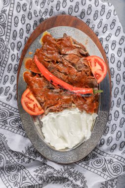 İskender kebabı, ayrıca Bursa kebabı olarak da bilinir, popüler bir Türk yemeğidir. İnce dilimlenmiş donör kebap etinden (genellikle kuzu veya sığır eti) oluşur ve pide ekmeğinde servis edilir..