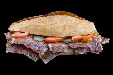 Siyah arka plandaki ekmek arasında et donörü. Geleneksel Türk mutfağı bağışçısı. Ekmek arasında et çevirici. Turşu ve domatesle servis edilir. (Türkçe adı: ekmek arasi et donör, Turk kebabi).