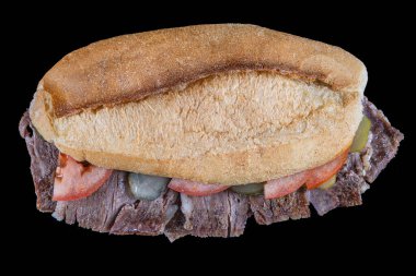 Siyah arka plandaki ekmek arasında et donörü. Geleneksel Türk mutfağı bağışçısı. Ekmek arasında et çevirici. Turşu ve domatesle servis edilir. (Türkçe adı: ekmek arasi et donör, Turk kebabi).