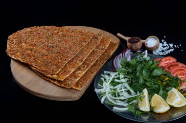 Geleneksel lezzetli Türk yemekleri lahmacun ve kıymalı kuzu eti. Geleneksel lezzetli Türk yemeği, Lahmacun. Lahmacun geleneksel Türk pizzası ve siyah arka planda izole edilmiş salatalı paket.